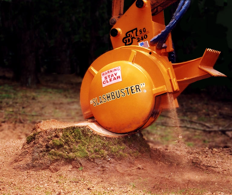 An orange stump grinder with "slashbuster" printed on it grinding a stump